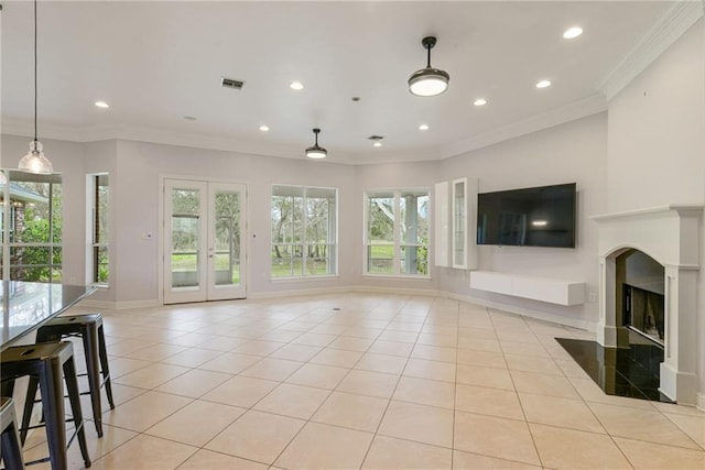 unfurnished living room featuring a fireplace, light tile patterned floors, a wealth of natural light, and crown molding