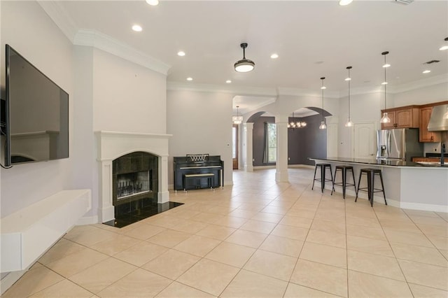 tiled living room featuring ornate columns and crown molding