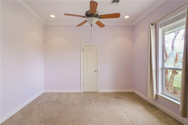 carpeted spare room with a wealth of natural light, ceiling fan, and ornamental molding