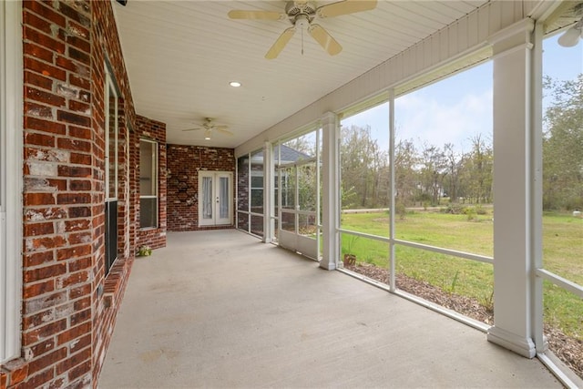 unfurnished sunroom with ceiling fan