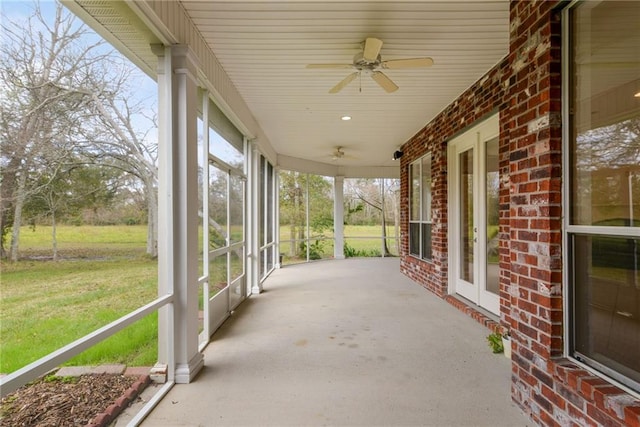 unfurnished sunroom with ceiling fan