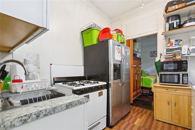 kitchen featuring white cabinetry, sink, light hardwood / wood-style floors, and appliances with stainless steel finishes