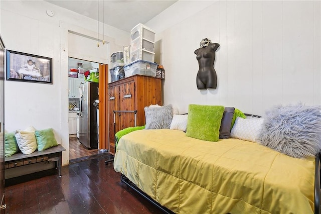 bedroom with stainless steel refrigerator and dark wood-type flooring