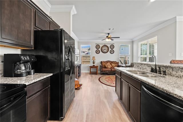 kitchen featuring ornamental molding, sink, light wood-type flooring, and black appliances