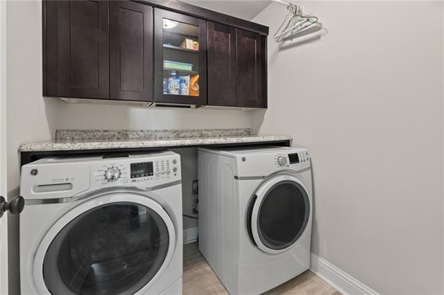 laundry room featuring washing machine and dryer and cabinets