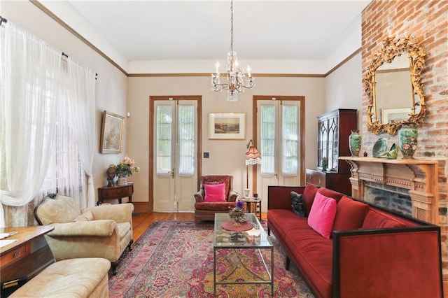 living room featuring hardwood / wood-style floors, a wealth of natural light, a fireplace, and a chandelier