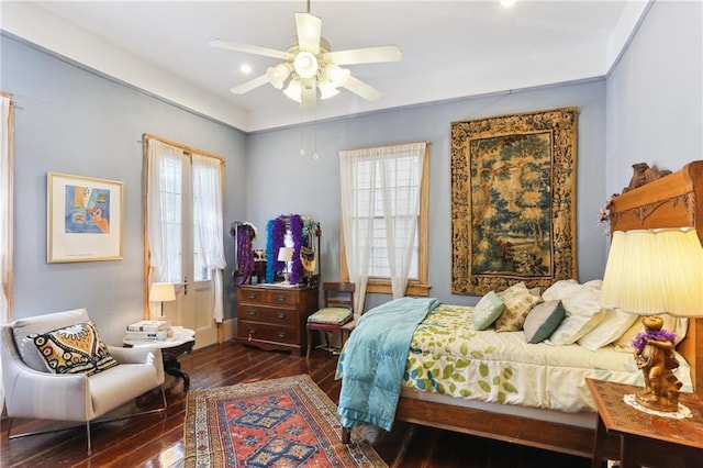 bedroom with dark hardwood / wood-style flooring and ceiling fan