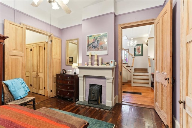 sitting room with dark hardwood / wood-style floors and ceiling fan with notable chandelier