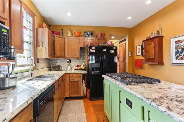 kitchen with plenty of natural light, sink, light hardwood / wood-style flooring, and black appliances