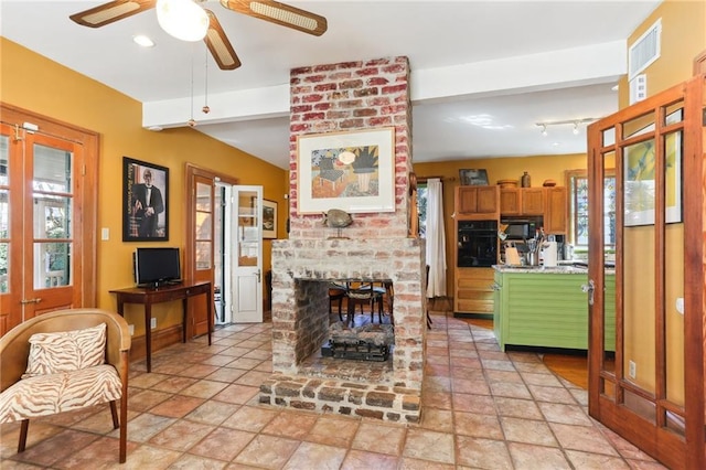 living room with a brick fireplace and ceiling fan