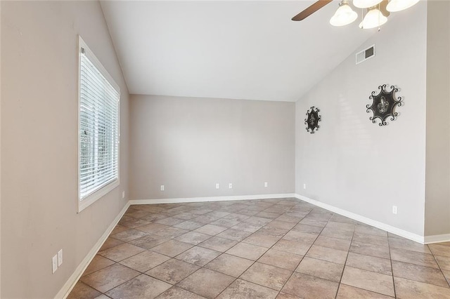 empty room featuring lofted ceiling, light tile patterned floors, and ceiling fan