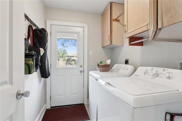 clothes washing area featuring washer and clothes dryer and cabinets