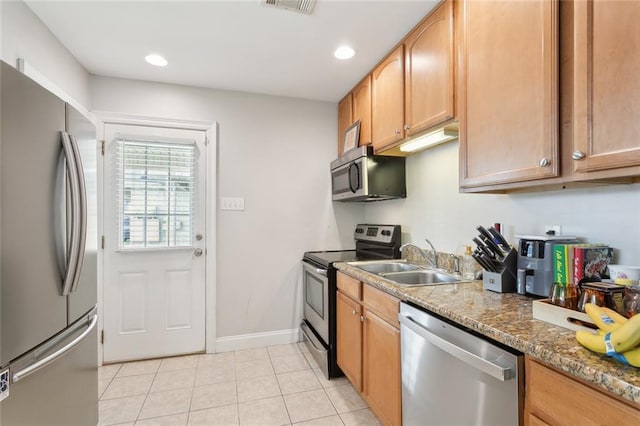 kitchen featuring stone counters, sink, light tile patterned flooring, and stainless steel appliances