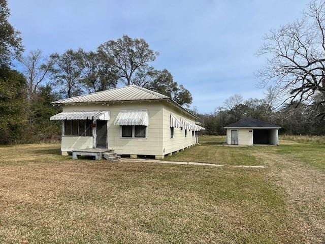 view of property exterior featuring a lawn and an outbuilding