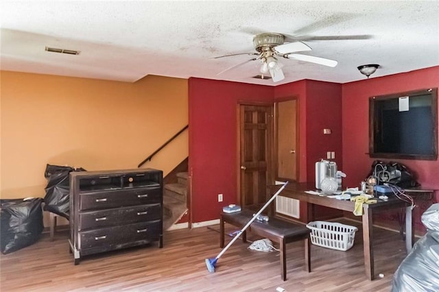 office space featuring ceiling fan, a textured ceiling, and hardwood / wood-style flooring