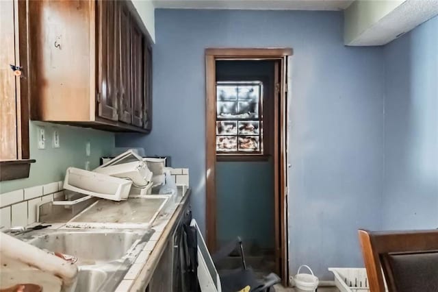 kitchen with dark brown cabinets, tile counters, and sink