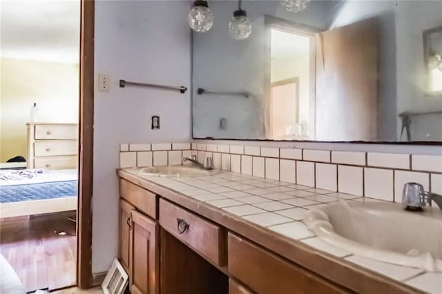 bathroom featuring decorative backsplash and vanity