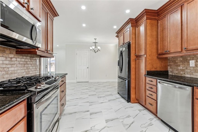 kitchen with dark stone counters, an inviting chandelier, tasteful backsplash, decorative light fixtures, and stainless steel appliances