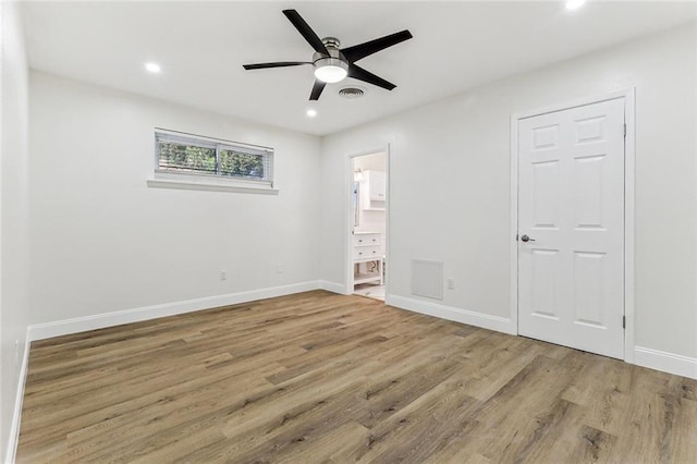 unfurnished bedroom with wood-type flooring, connected bathroom, and ceiling fan