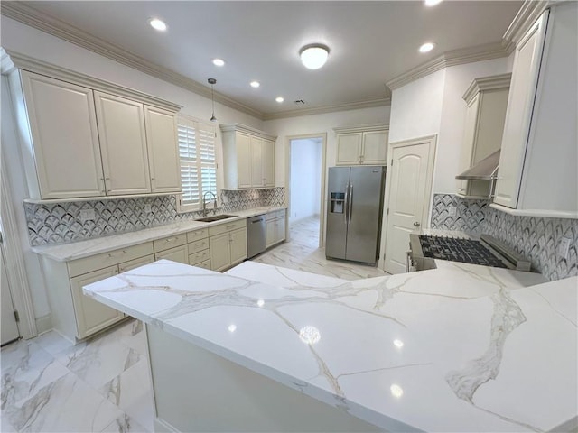 kitchen with light stone countertops, appliances with stainless steel finishes, decorative backsplash, wall chimney exhaust hood, and sink