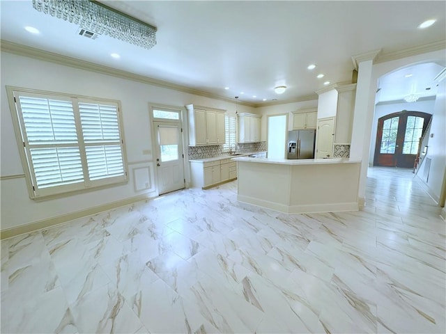 kitchen with stainless steel fridge, backsplash, a wealth of natural light, and french doors