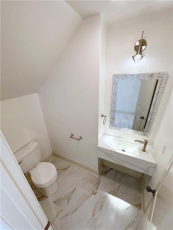 bathroom with lofted ceiling and toilet