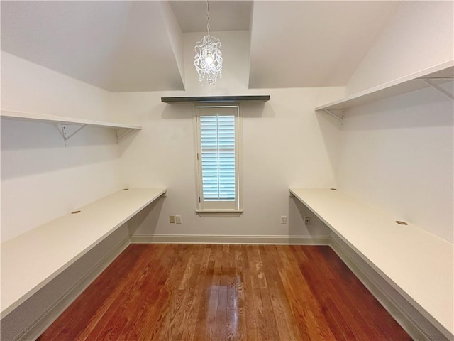 walk in closet featuring dark hardwood / wood-style floors and an inviting chandelier