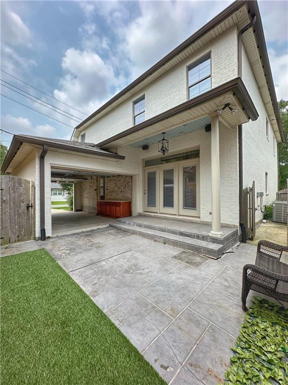 view of front of house featuring central AC unit, a patio area, covered porch, and a front lawn