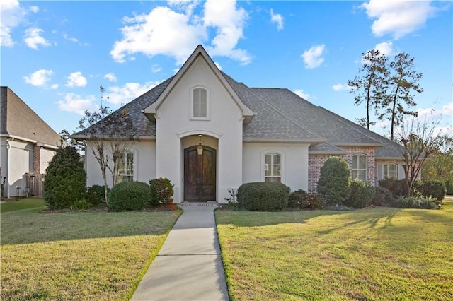 524 Belle Pointe Loop, Madisonville, LA 70447 - french country inspired facade with stucco siding, a front lawn, a shingled roof, and french doors