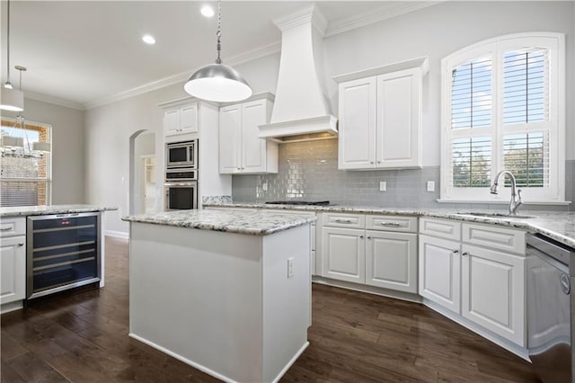 kitchen with wine cooler, a center island, white cabinets, and premium range hood