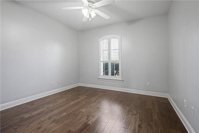 spare room with dark wood-type flooring and ceiling fan