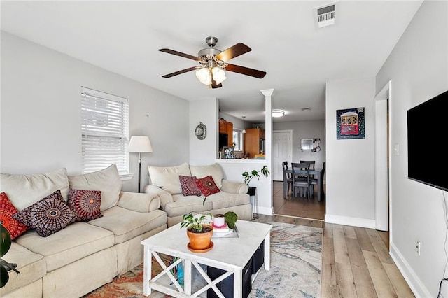 living room featuring light hardwood / wood-style flooring and ceiling fan