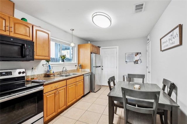 kitchen with sink, light tile patterned flooring, pendant lighting, and appliances with stainless steel finishes