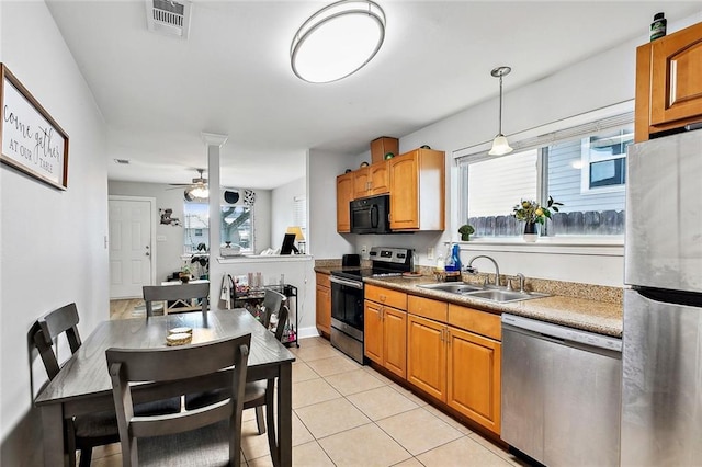 kitchen with stainless steel appliances, plenty of natural light, hanging light fixtures, and sink