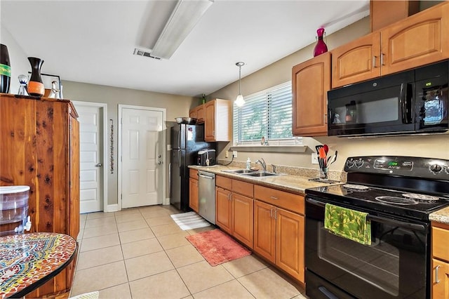 kitchen with light stone countertops, sink, black appliances, pendant lighting, and light tile patterned flooring