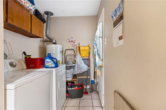 washroom featuring washer and dryer, gas water heater, cabinet space, and light tile patterned flooring