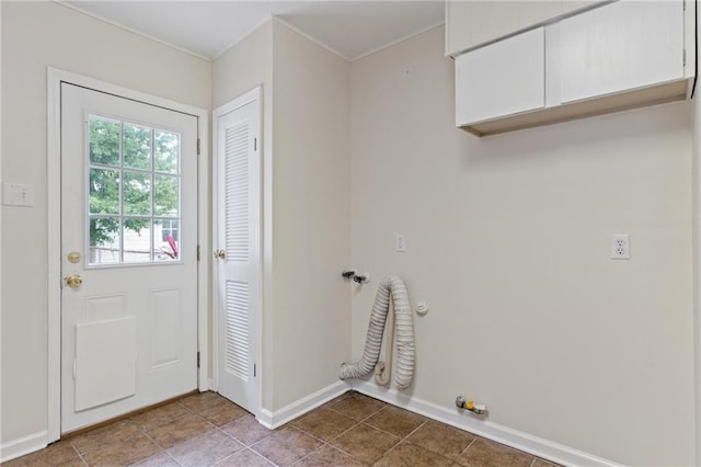 clothes washing area with baseboards, tile patterned floors, cabinet space, and hookup for a gas dryer