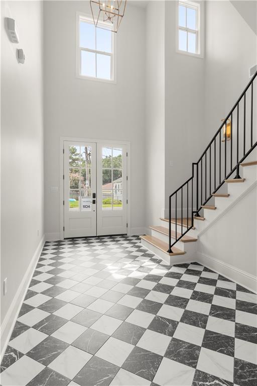 entryway with a towering ceiling and french doors