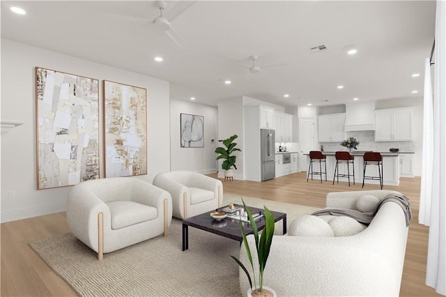 living room featuring ceiling fan and light hardwood / wood-style flooring