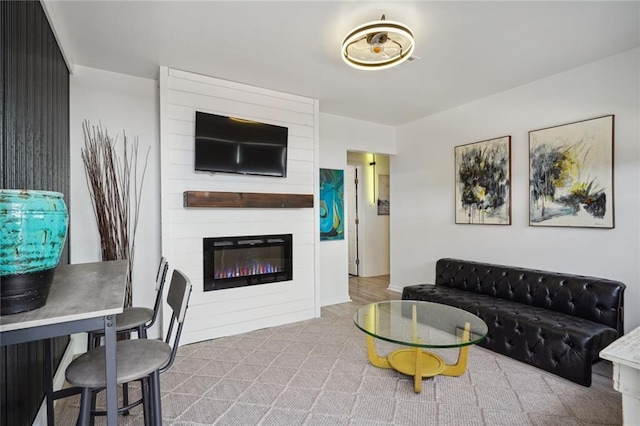 living room with a large fireplace and light colored carpet