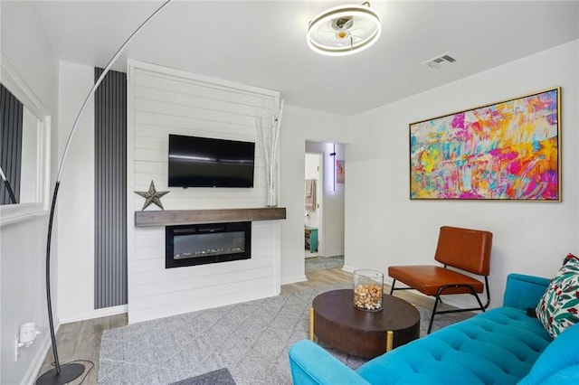 living room featuring a large fireplace and light hardwood / wood-style flooring