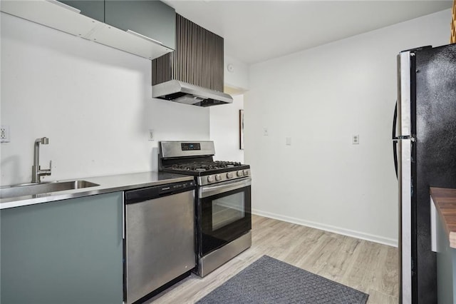 kitchen featuring appliances with stainless steel finishes, sink, and light hardwood / wood-style flooring