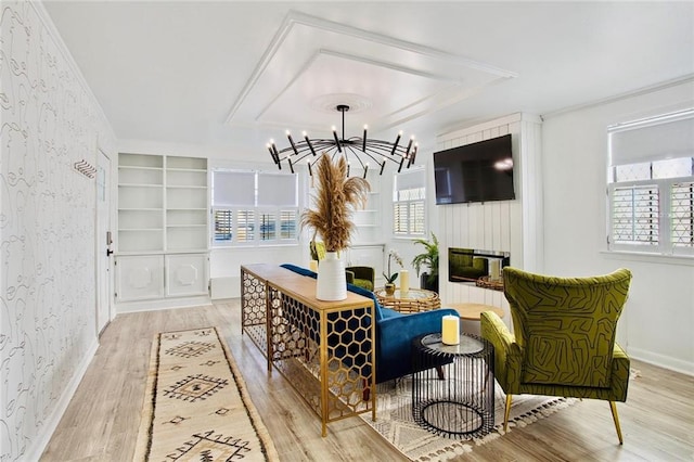 2604 Chartres St, New Orleans, LA 70130 - sitting room with wallpapered walls, light wood-style floors, a chandelier, ornamental molding, and a tray ceiling
