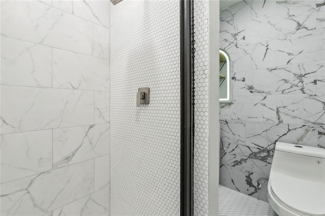 2604 Chartres St, New Orleans, LA 70130 - bathroom featuring a tile shower, toilet, and tile walls