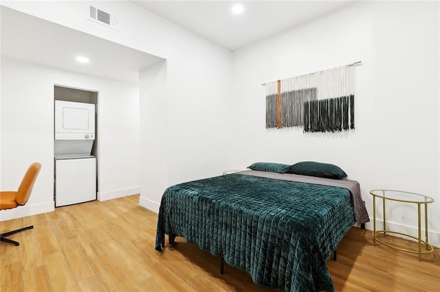 2604 Chartres St, New Orleans, LA 70130 - bedroom featuring stacked washer and clothes dryer, wood finished floors, baseboards, and recessed lighting