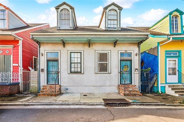 1512 Saint Ann St, New Orleans, LA 70116 - view of exterior entry with a shingled roof and stucco siding