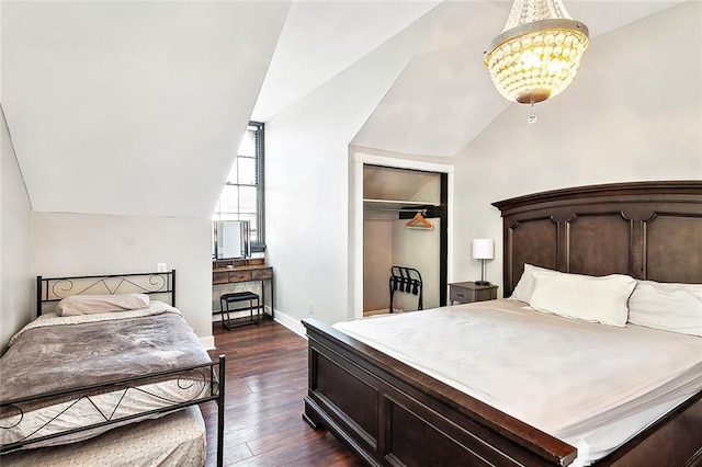 bedroom featuring an inviting chandelier, dark hardwood / wood-style floors, vaulted ceiling, and a closet