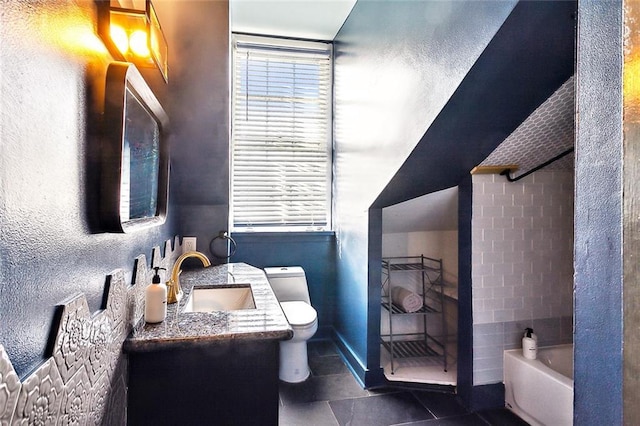 bathroom with vanity, a bathing tub, and toilet