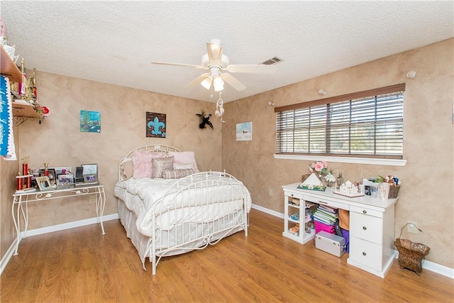 bedroom featuring a textured ceiling, hardwood / wood-style flooring, and ceiling fan