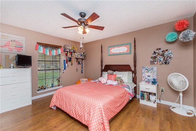 bedroom with wood-type flooring, a textured ceiling, and ceiling fan